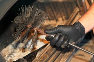 Main de ramoneur avec outil pour nettoyer conduit cheminée